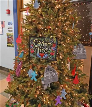 tree holding donated items like hats